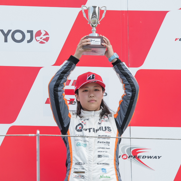 Official team driver holding a trophy after placing 3rd in Race 1